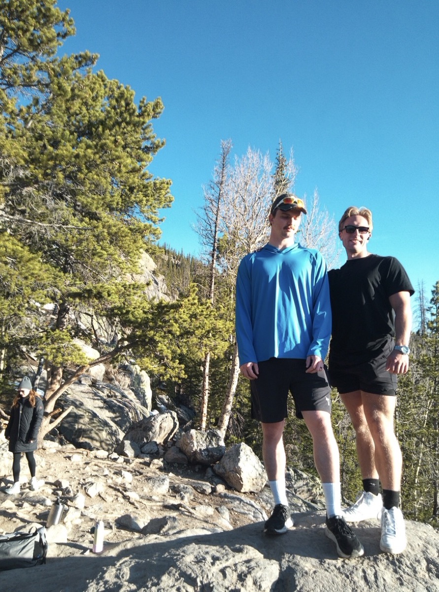 Nick and a friend hiking, standing on a rocky overlook