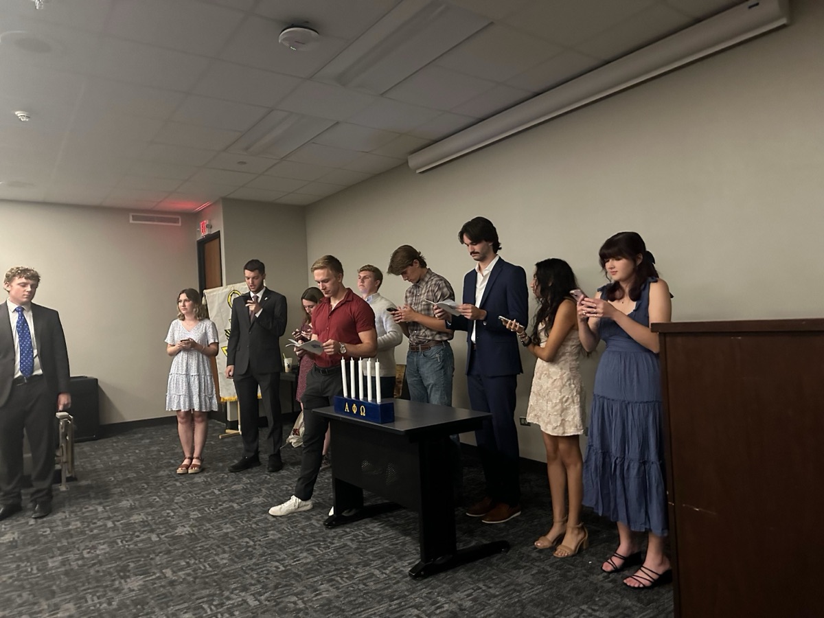 Nick and friends standing at a candle-lighting ceremony