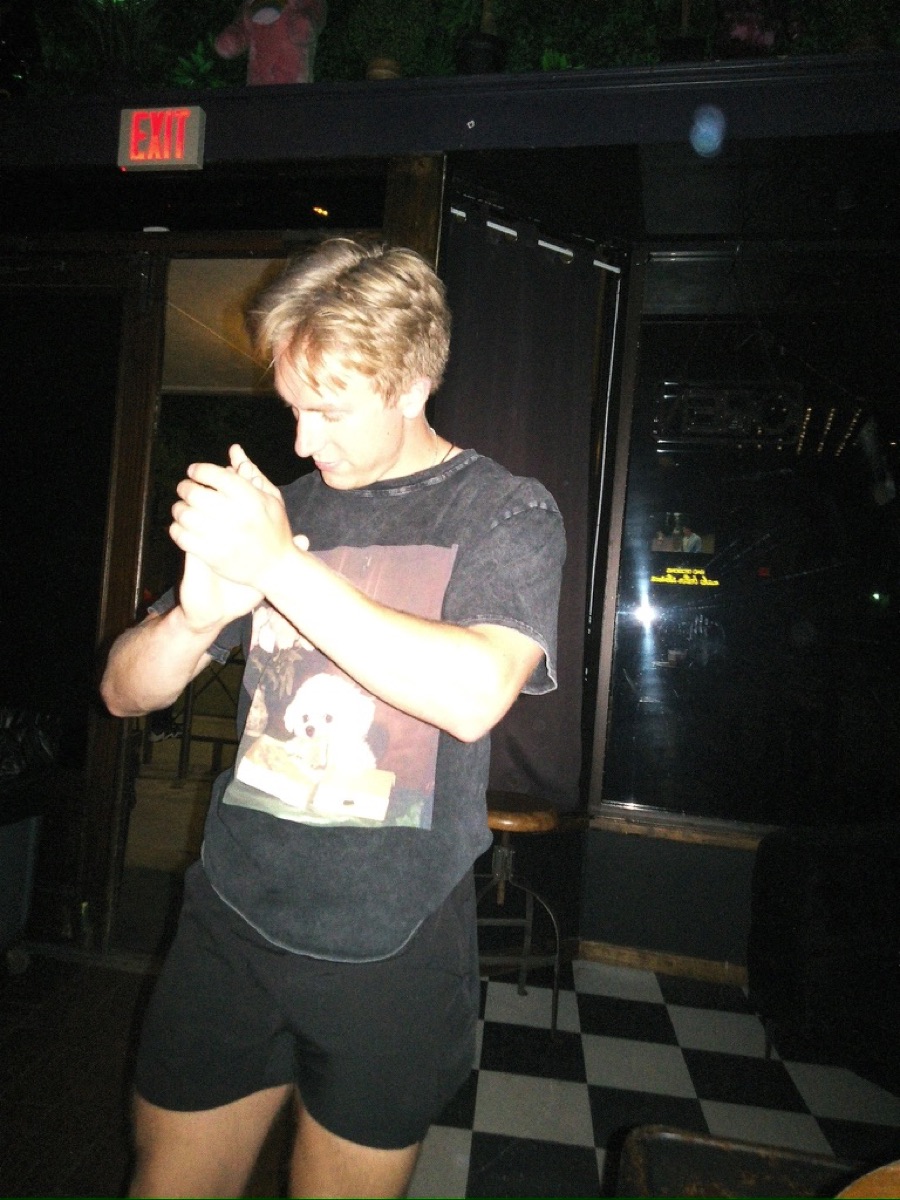 Nick dancing and laughing with a friend at a bar