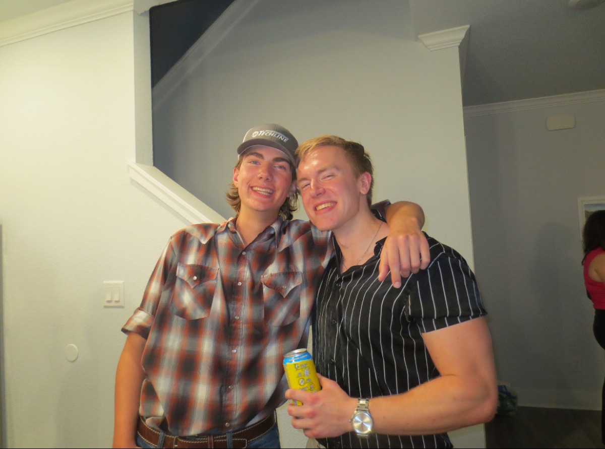 Nick with his arm around a friend at a get-together