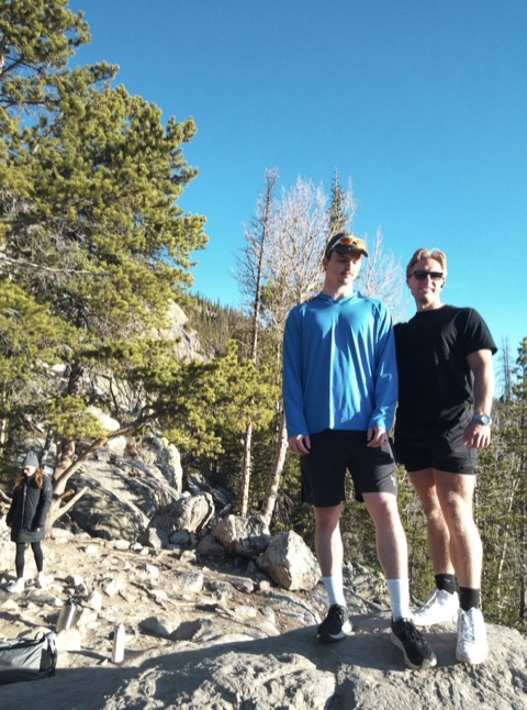 Nick and a friend hiking, standing on a rocky overlook